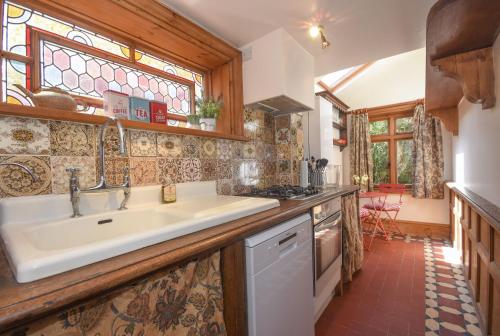 eine Küche mit einem Waschbecken und einem Fenster in der Unterkunft Unique period one bedroom house in Colchester in Colchester