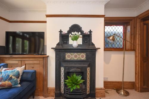 a living room with a black fireplace with a vase on it at Unique period one bedroom house in Colchester in Colchester