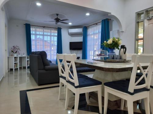 a kitchen and living room with a table and chairs at Beit Azzahra Private Pool Villa at Pantai Batu Hitam in Kuantan