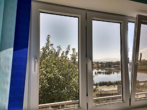 a room with three windows with a view of a lake at Lake House Gyumri in Noraber