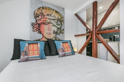 1 dormitorio con 1 cama con una pintura en la pared en Alfama Lyfe, en Lisboa