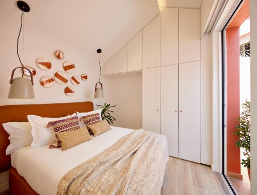 a bedroom with a large bed with white walls at Bougainvillea 33 by My Cozy Home in Faro