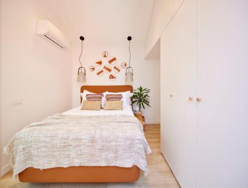 um quarto com uma cama grande e paredes brancas em Bougainvillea 33 by My Cozy Home em Faro