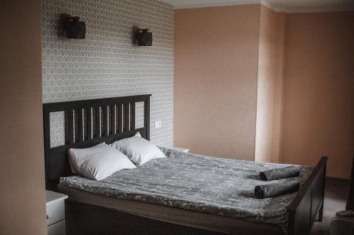 um quarto com uma cama com almofadas em Rabbit Hotel em Raiskums