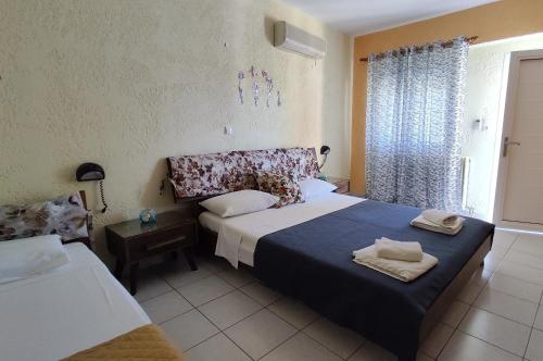 ein Schlafzimmer mit zwei Betten und einem Fenster in der Unterkunft Mpezas Studios in Igoumenitsa
