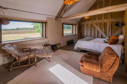 a bedroom with a bed and a large window at La Planque en Perche in Bellou-le-Trichard