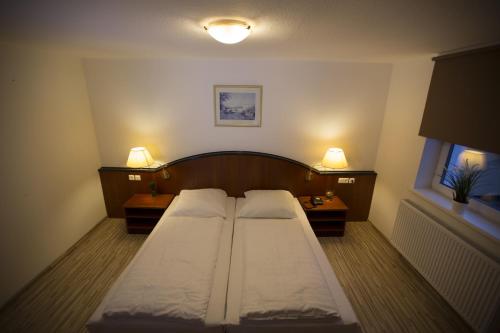 a small bedroom with two beds and two lamps at AS Hotel in Göttingen