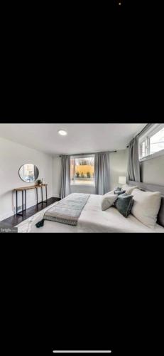 a bedroom with a large white bed with a window at Lovely 1-bedroom rental unit with free parking in Washington, D.C.