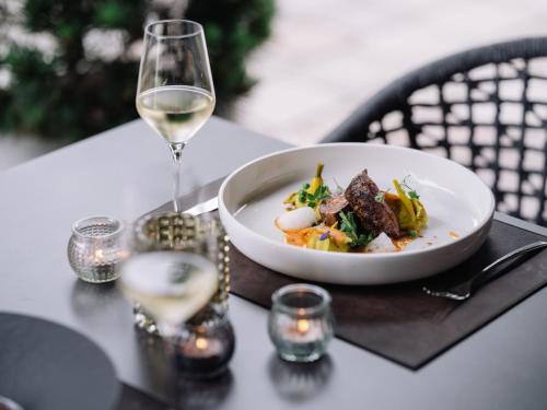 a plate of food and a glass of wine on a table at JOHANN Schladming in Schladming