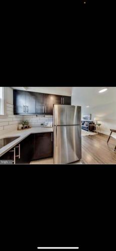 a large kitchen with a stainless steel refrigerator at Lovely 1-bedroom rental unit with free parking in Washington, D.C.