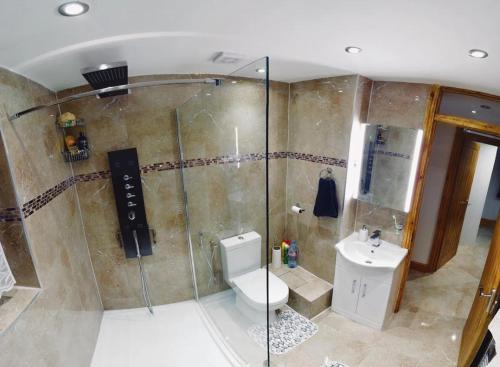 a bathroom with a shower and a toilet and a sink at Stratford city apartments in London