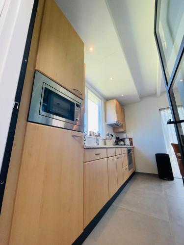 a kitchen with a refrigerator and a microwave at Kustverhuur, Park Schoneveld, Zeester 63 in Breskens