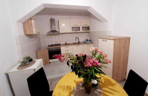 a kitchen with a table with a vase of flowers on it at Oaza in Komarna