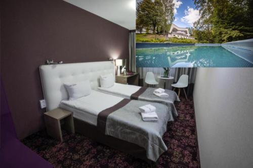 a bedroom with a bed with a large painting on the wall at Hotel Ameliówka in Masłów
