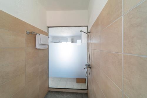 a bathroom with a shower with a glass door at Yiasemi Apartments in Faliraki