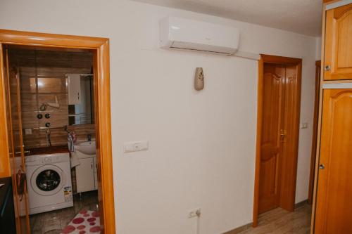 une cuisine avec un lave-linge et un sèche-linge sur le mur dans l'établissement Guest House Ahmo Halilcevic, à Dubrave Gornje