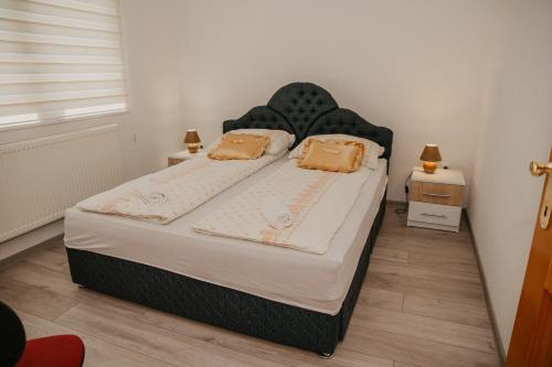 a bedroom with a large bed with two pillows at Guest House Ahmo Halilcevic in Dubrave Gornje