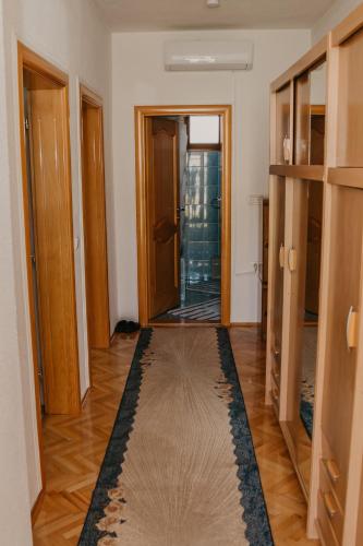 a hallway with wooden doors and a rug on the floor at Guest House Ahmo Halilcevic in Dubrave Gornje