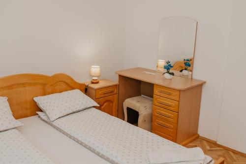a bedroom with two beds and a desk with a mirror at Guest House Ahmo Halilcevic in Dubrave Gornje
