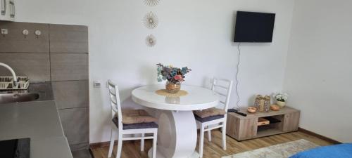 una pequeña mesa blanca en una habitación con sillas en Apartman Studio Teona en Nova Varoš
