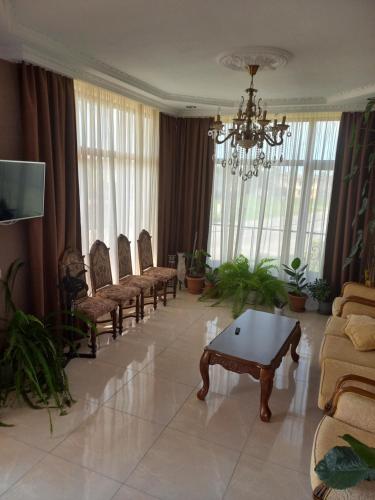 - un salon avec des chaises, une table et un lustre dans l'établissement Sunrise - Guest House, à Anaklia
