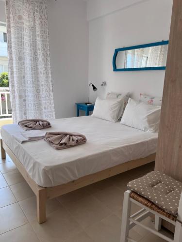 1 dormitorio con 1 cama y 1 silla en Aqua Theros Apartments, en Paralia Dionisiou