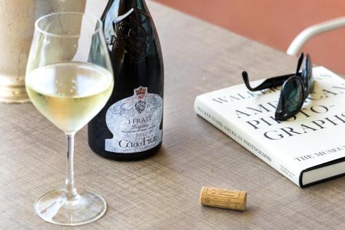 a glass of white wine next to a bottle of wine at Hotel Aquila D'Oro Desenzano in Desenzano del Garda