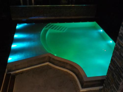 vistas a una piscina con iluminación verde en EL GAVION a 150 m de playa en Balneario Mar Azul