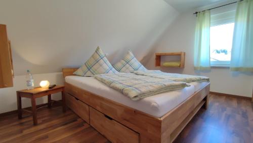 a bedroom with a large bed with a window at Ferienhaus Rudolf in Achberg