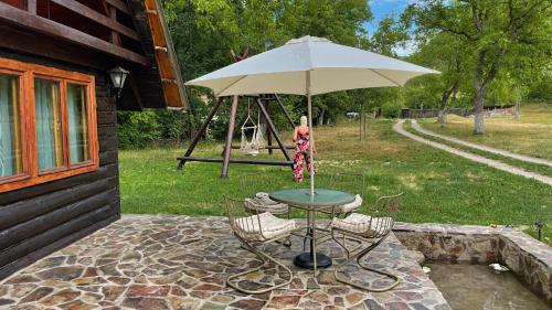a table with an umbrella on a patio at Cabana Paulina in Chişcău
