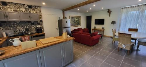 Il comprend une cuisine et un salon avec un canapé rouge et une table. dans l'établissement Le Moulin Des Fumades, à Payrignac