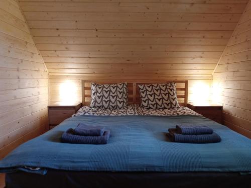 łóżko w drewnianym pokoju z 2 poduszkami w obiekcie Otulina Gulczewo w mieście Wyszków