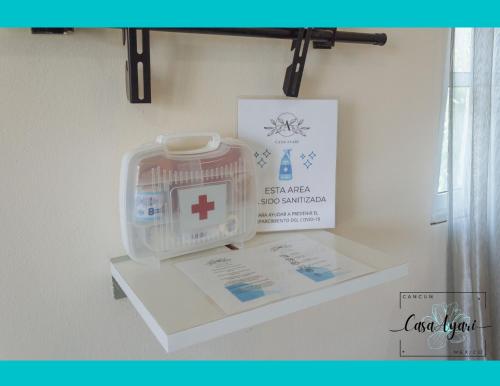 a shelf with a first aid kit and a sign on a wall at Casa Ayari - 3 Habitaciones - 2 a 6 personas - WIFI- AC in Cancún