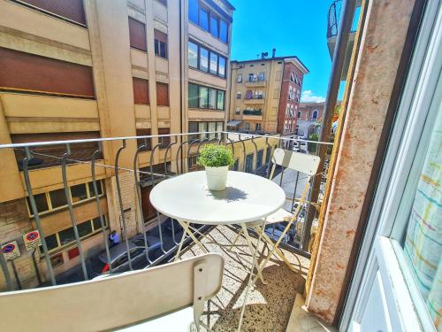 un balcón con una mesa blanca y una planta. en LC ROOMS Pisa, en Pisa