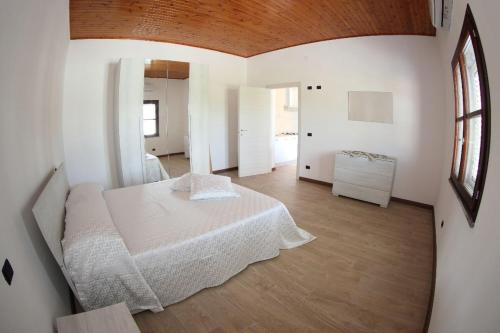 una camera bianca con un letto e una finestra di LA PACE DEGLI AGRUMI a Pannaconi
