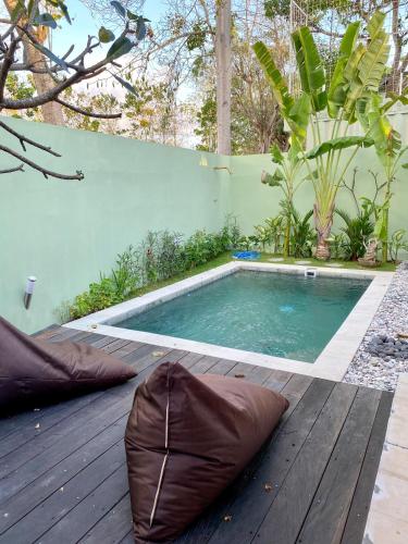 a swimming pool with pillows on a wooden deck at 2BR Art Villa Bingin in Uluwatu
