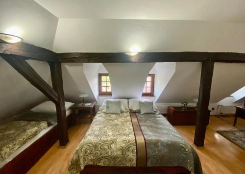 a bedroom with a large bed in an attic at Kaštieľ Benice in Príbovce