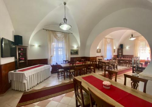 a large room with tables and chairs and a bed at Kaštieľ Benice in Príbovce