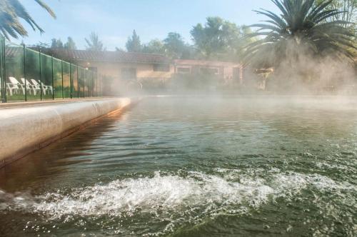 a body of water with a building in the background at Hotel Termales El Batan in Cuítiva