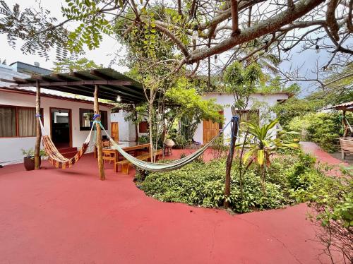 a porch with a hammock and a house at Hostal Vista al Mar in Puerto Ayora