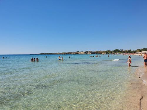 a group of people in the water at the beach at Villa Rita Apartment in Fontane Bianche