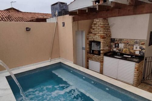 A piscina localizada em A Casa Linda Com Piscina Aquecida churrasqueira wifi pertinho da praia em Itanhaém ou nos arredores
