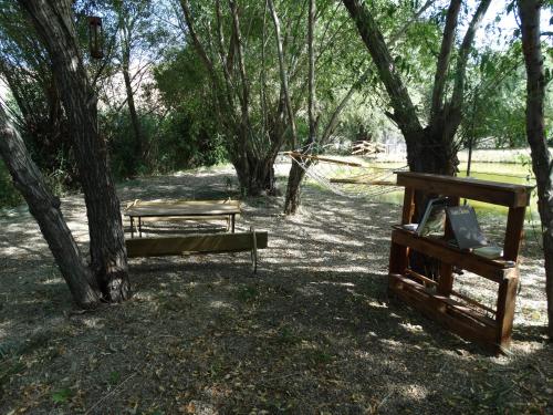 a park with two benches and a hammock under trees at Village Jazz in Chimankend
