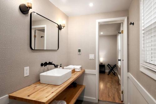 La salle de bains est pourvue d'un lavabo blanc et d'un miroir. dans l'établissement *NEW* Large Backyard ~ Game Room ~ Firepit ~ Lake, à Skaneateles