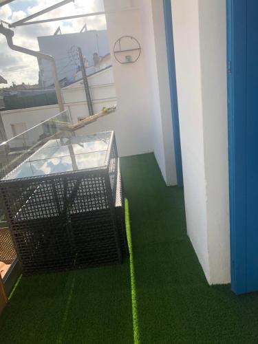 un balcon avec un sol vert et une horloge au mur dans l'établissement Là-Haut, à Royan