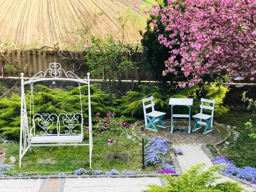 twee stoelen en een tafel in een tuin met bloemen bij Casa cu Suflet in Sighişoara