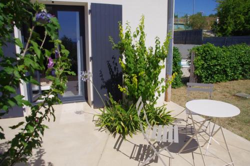 a patio with a table and a plant at Le Grand Cèdre - 2 Chambres d'hôtes - Sud Ardèche in Bourg-Saint-Andéol