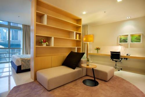 a room with a couch and a table and a bed at PARKROYAL Serviced Suites Kuala Lumpur in Kuala Lumpur