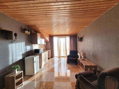 una sala de estar con techos de madera y una sala de estar con sillas. en Homelike B&B en Tiflis