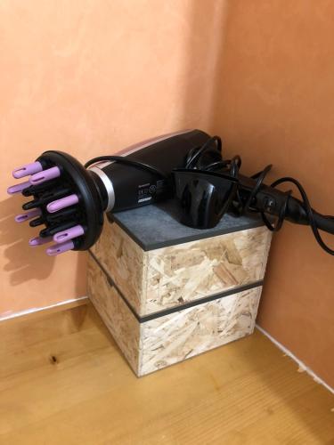 a hair dryer sitting on top of a box at SUPER BESSE Appartement LE GÎTE BESSARD 6 couchages Le Bois de la Reine in Besse-et-Saint-Anastaise